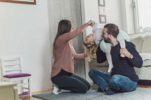 a man and a woman are playing with a little girl