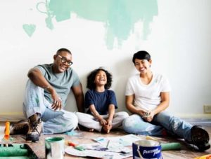 couple and daughter painting home